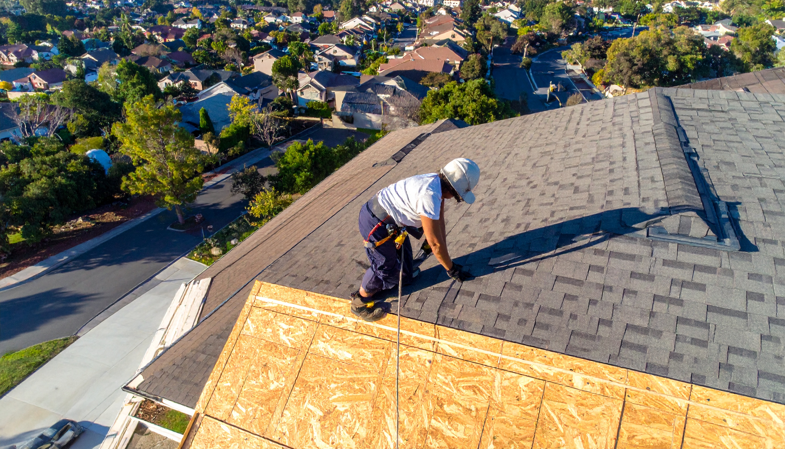 Roofer installing shingles on residential roof